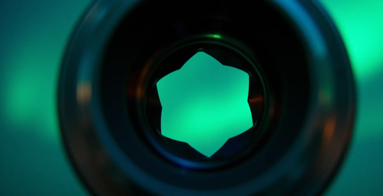 Close-up of camera lens aperture blades with northern lights reflection